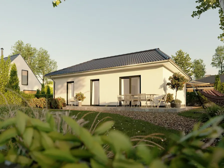 Bungalow 78 in heller Putzoptik mit einladender Terrasse und gepflegtem Garten, fotografiert bei Sonnenschein aus Gartenperspektive.